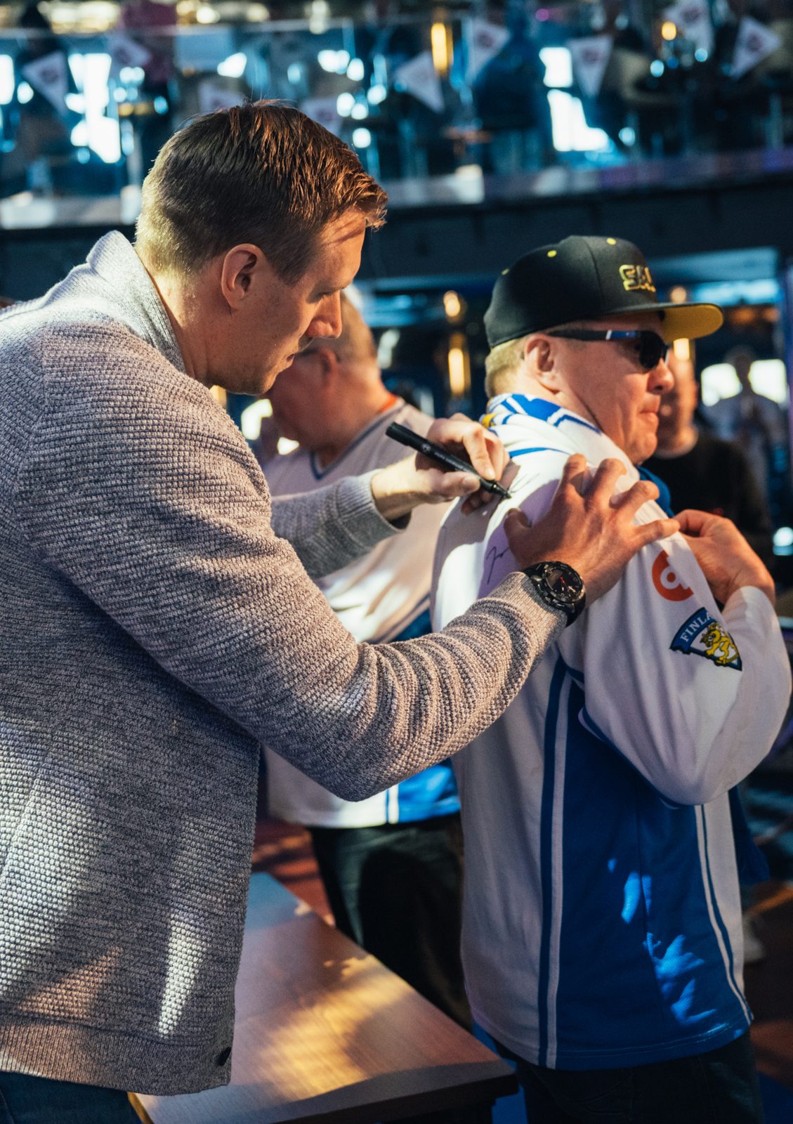 Leijona-legenda jakaa nimikirjoituksen fanin pelipaitaan kisatapahtumassa